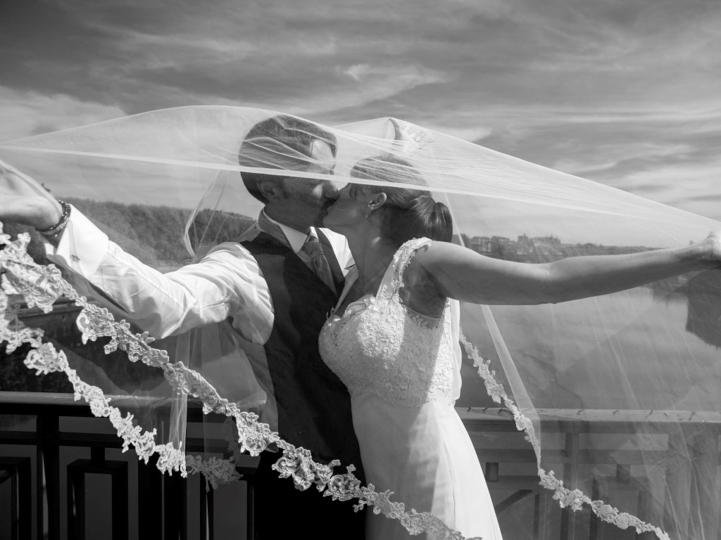 baiser des mariés sous un voile en dentelle 