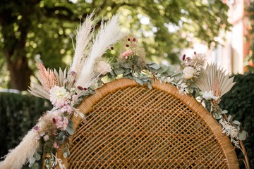 Déco feuillage et fleurs séchées fauteuil en osier cérémonie