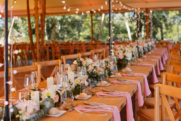 Tables en bois fleuries et serviettes roses 