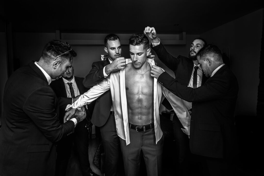 Les garçons d’honneur aident le marié à s’habiller